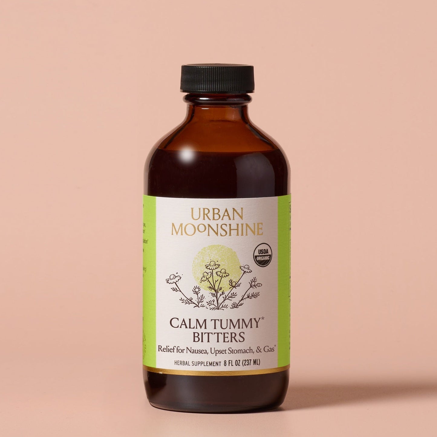 Bottle of Urban Moonshine Calm Tummy Bitters on a beige background