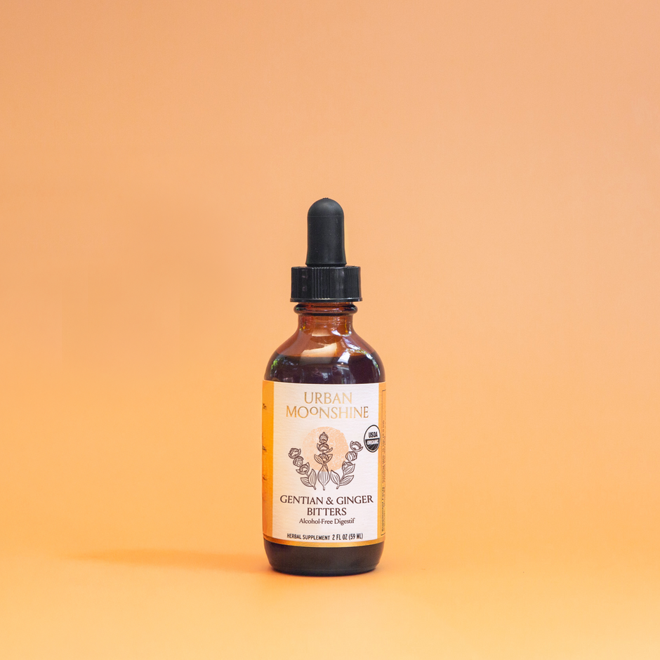 Bottle of organic gentian & ginger bitters on a gradient orange background
